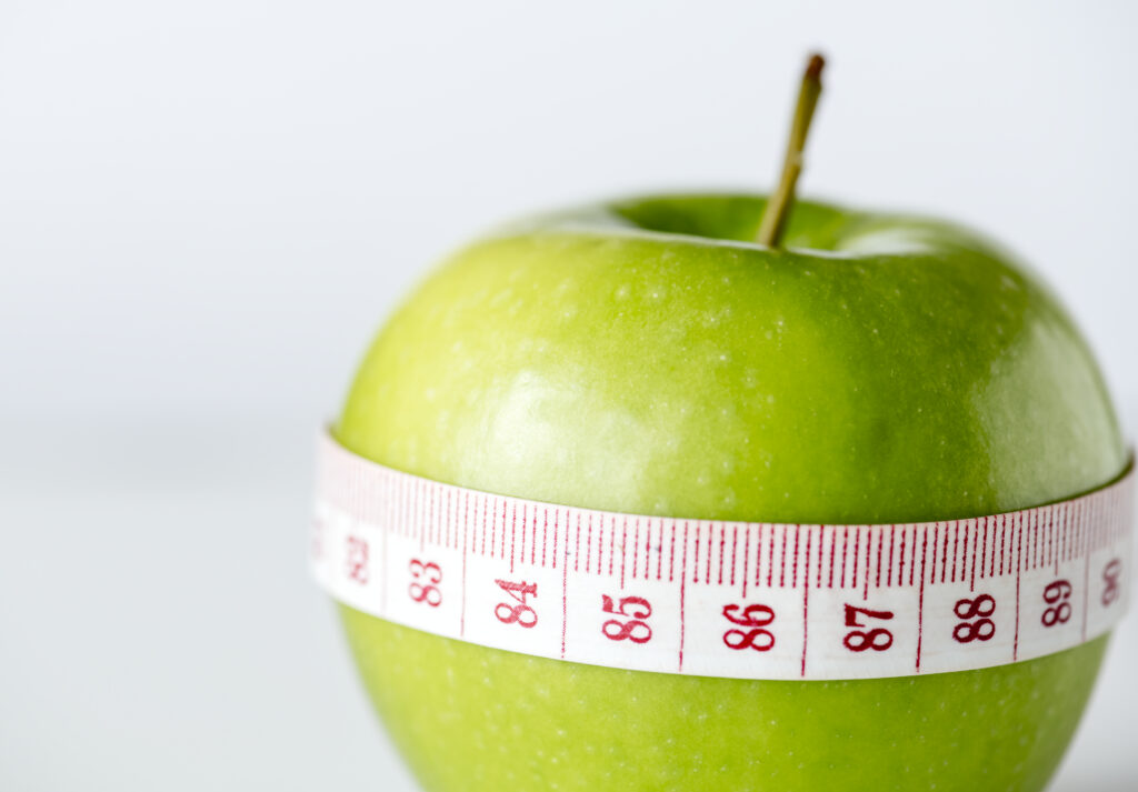 Ett äpple med ett måttband runt.